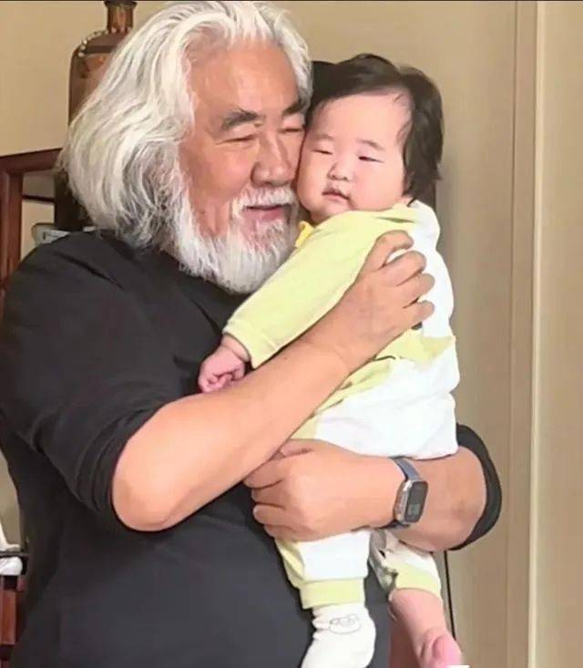 张纪中太宠4胎女儿，把6个月龙珠举高亲脸颊，带娃应酬抱着不撒手