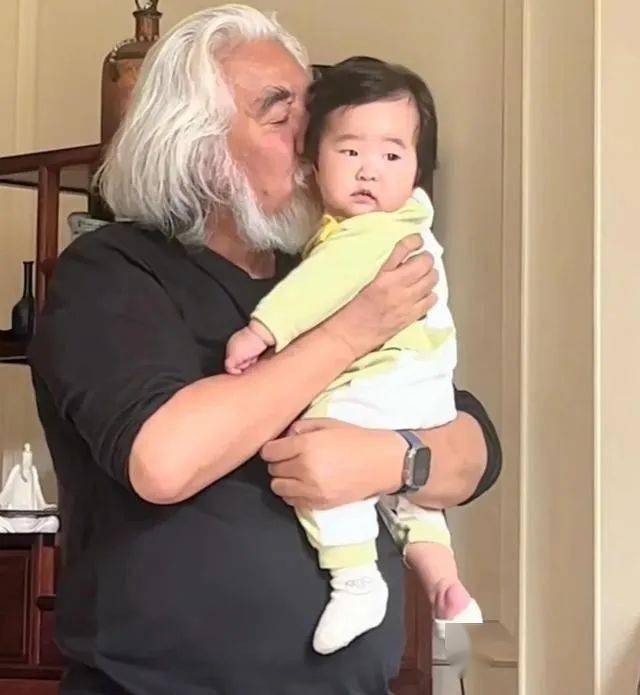 张纪中太宠4胎女儿，把6个月龙珠举高亲脸颊，带娃应酬抱着不撒手