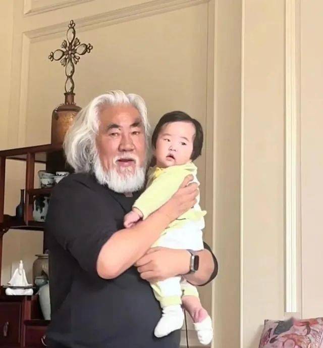 张纪中太宠4胎女儿，把6个月龙珠举高亲脸颊，带娃应酬抱着不撒手